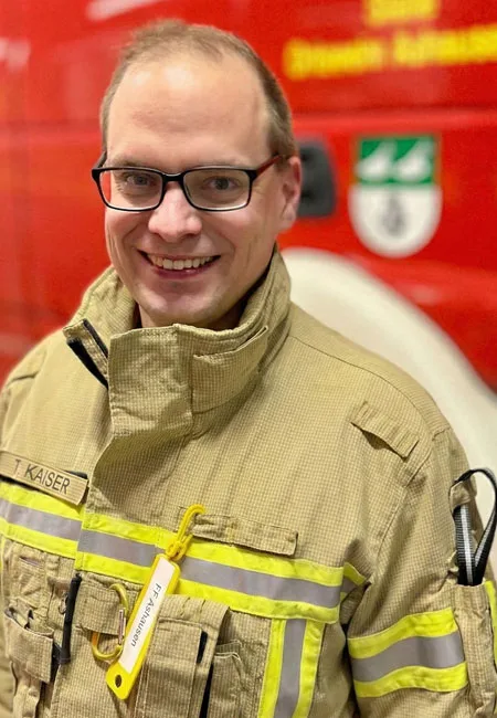 Tim Kaiser in Einsatzkleidung der Freiwilligen Feuerwehr Ashausen, vor dem Löschfahrzeug
